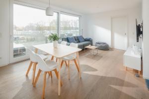 een woonkamer met een tafel en stoelen en een bank bij Seebär Norderney in Norderney