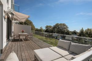 een patio met een bank en een tafel op een balkon bij Seebär Norderney in Norderney