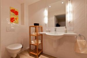 ein Badezimmer mit einem Waschbecken, einem WC und einem Spiegel in der Unterkunft Sonne 3 in Norderney