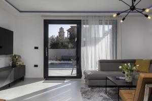 Villa M Premantura في بريمونتيرا: غرفة معيشة مع أريكة وباب زجاجي منزلق