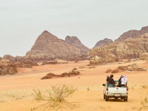 a group of people in the back of a truck in the desert at Panorama camp jeep trips in Wadi Rum