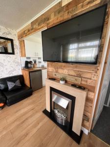 a living room with a fireplace and a flat screen tv at Signature, Scratby - Two bed chalet, sleeps 7, free Wi-Fi, free entry to onsite clubhouse - no pets in Scratby