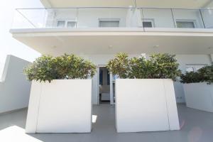 a row of white planters with plants in them at Terrazze Naos in San Leone