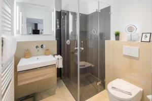een badkamer met een douche, een toilet en een wastafel bij Sommerdeich4you in Norderney