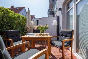 d'une terrasse avec une table et des chaises sur un balcon. dans l'établissement Skagen, à Norderney