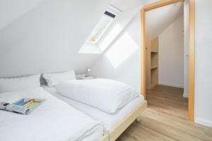 1 dormitorio con cama blanca y ventana en Windrose 19 en Norderney