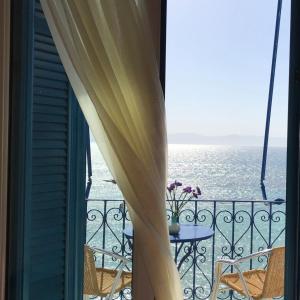 uma varanda com uma mesa e vista para o oceano em Hotel Areti em Egina