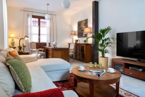 a living room with a white couch and a tv at MonKeys Apartments Alameda House in Seville