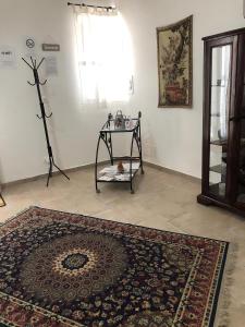 Habitación con mesa y alfombra en el suelo en casa salusa en Terrasini Favarotta