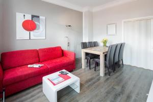 Una sala de estar con un sofá rojo y una mesa. en Villa Stefanie 2, en Norderney