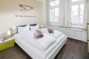 Un dormitorio con una gran cama blanca con dos almohadas. en Villa Stefanie 2, en Norderney
