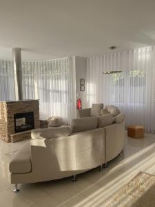 a living room with a couch and a fireplace at Luxury villa with private heated pool, garden and views of the sea and mountains. in Arco da Calheta