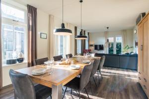 a dining room with a large wooden table and chairs at Staetige Dames in Nes