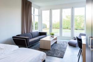 a hotel room with a bed and a couch and a table at Staetige Dames in Nes