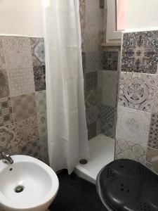 baño con lavabo y cortina de ducha blanca en casa salusa en Terrasini Favarotta