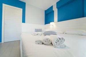 a bedroom with a white bed with blue walls at Terrazze Naos in San Leone
