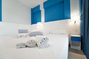 a bedroom with a white bed with towels on it at Terrazze Naos in San Leone