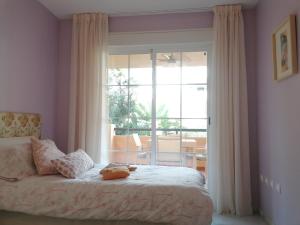 sypialnia z łóżkiem i dużym oknem w obiekcie Beach & Golf Design Apartment Marbella w Marbelli