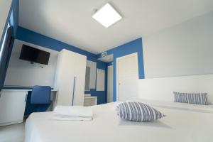 a bedroom with blue walls and a bed with a pillow at Terrazze Naos in San Leone
