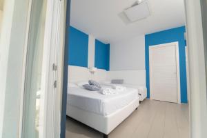 a bedroom with blue and white walls and a bed at Terrazze Naos in San Leone