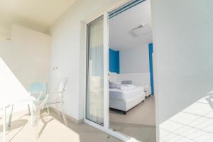a white room with a bed and a glass door at Terrazze Naos in San Leone