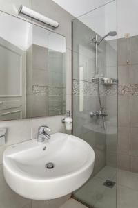 a bathroom with a white sink and a shower at Alkyoni Studios in Andros