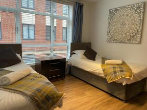 מיטה או מיטות בחדר ב-Zen Modern 2 Bedroom Apartment close to city centre ideal for a group of 4-6