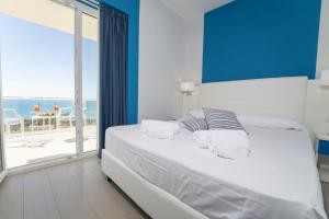a bedroom with a bed with a view of the ocean at Terrazze Naos in San Leone
