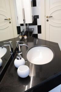 een badkamer met 2 wastafels en een zwart aanrecht bij San Colin casa vacanze in Conversano