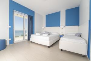 two beds in a room with a view of the ocean at Terrazze Naos in San Leone