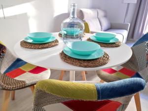 ein weißer Tisch mit Tellern und einer Glasflasche darauf in der Unterkunft Apartamentos Js Sol Rastro in Úbeda