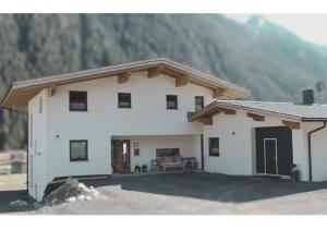 a white house with a mountain in the background at Apartment VIERSTERNE in Neustift im Stubaital
