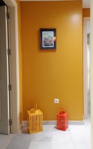 Żółta ściana z dwoma koszami i zdjęciem w obiekcie Beach & Golf Design Apartment Marbella w Marbelli