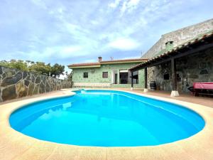a large blue swimming pool in front of a house at Villa with private pool and great view of the Atlantic Ocean in Adeje