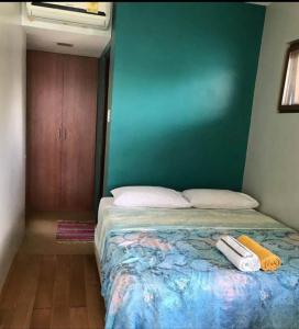 1 dormitorio con cama y pared verde en NaturesWay/TRAVELCORON, en Corón