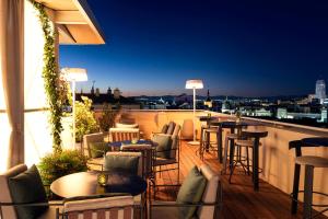 a rooftop bar with chairs and tables on a balcony at UMusic Hotel Madrid in Madrid