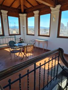 a balcony with a table and chairs and windows at Soggiorno Isabella De' Medici in Florence