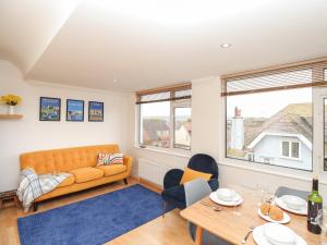 a living room with a couch and a table at Nine Barrow View in Swanage