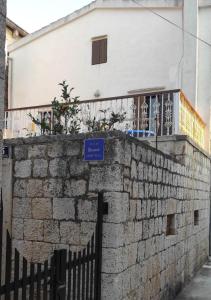 a building with a blue sign on a brick wall at Nona Ružica in Vis