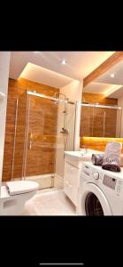 a bathroom with a shower and a washing machine at Downtown Apartments Presley air-conditioned in Rzeszów