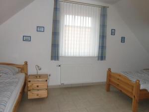 - une chambre avec 2 lits et une fenêtre dans l'établissement Seestern, à Bensersiel