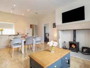 a living room with a table and a fireplace at Pond Cottage in Alnwick