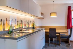 eine Küche mit einem Waschbecken und einem Tisch in der Unterkunft Apartments Gojer Vernatsch in Karneid