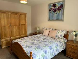 - une chambre avec un lit et une armoire en bois dans l'établissement The Old Stables - a gem surrounded by mountains!, à Caernarfon