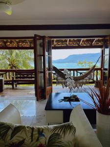 a living room with a couch and a hammock at Mooi Guest House in Ilhabela