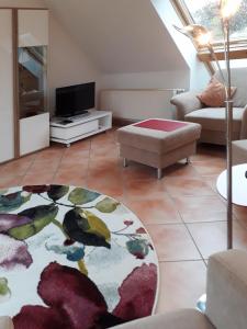 a living room with a couch and a tv at Traumblick und Komfort - lichtdurchflutete 85 qm Wohnung nahe Südstrand Göhren inklusive Schwimmbad und Sauna im AHOI Sellin in Göhren