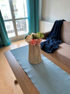 a vase filled with flowers sitting on a table at Al-Dom Apartamenty Dworcowa 9 in Kołobrzeg