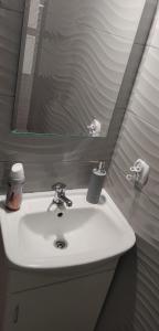a white sink in a bathroom with a mirror at Hostel u Misiów in Suwałki