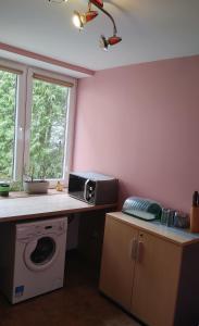 a kitchen with a washing machine and a microwave at Hostel u Misiów in Suwałki