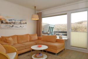 uma sala de estar com um sofá e uma grande janela em Riebschlaeger-Stranduebergang-K-Christiansen em Westerland